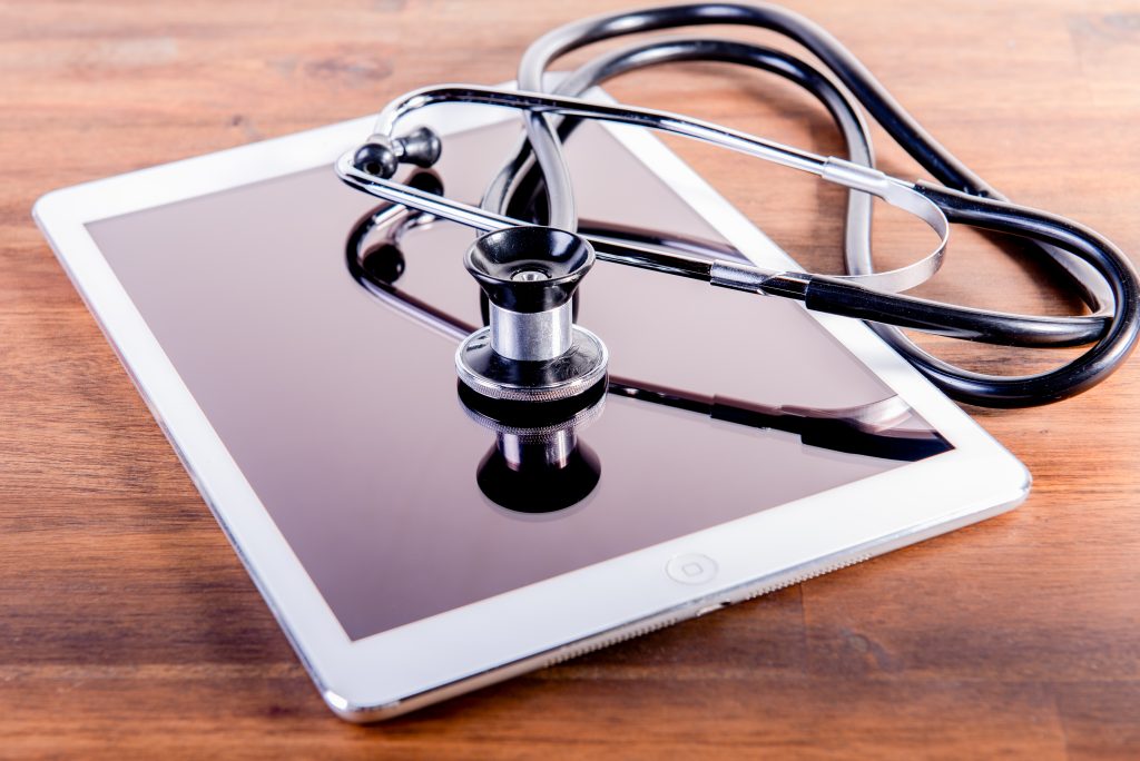 medical stethoscope and tablet on brown wooden background. Health care concept. phonendoscope.