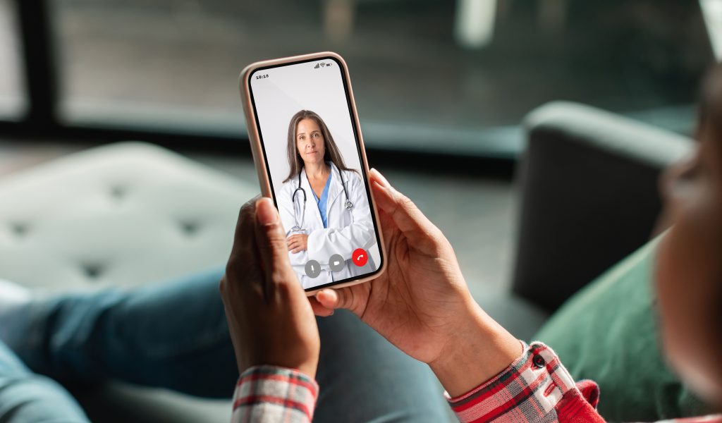 Telemedicine. Unrecognizable Woman Using Smartphone, Making Video Conference With Her Therapist Doctor