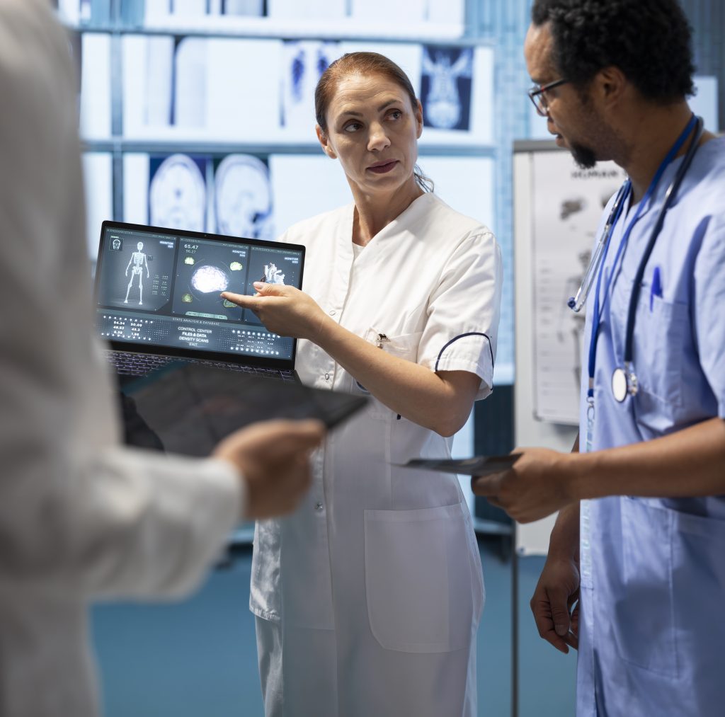 Medical team examining x ray scan results to discuss patient care options. Group of licensed cardiologists analyzing cardiac issues on a ecg radiography, effective treatment in a clinic.